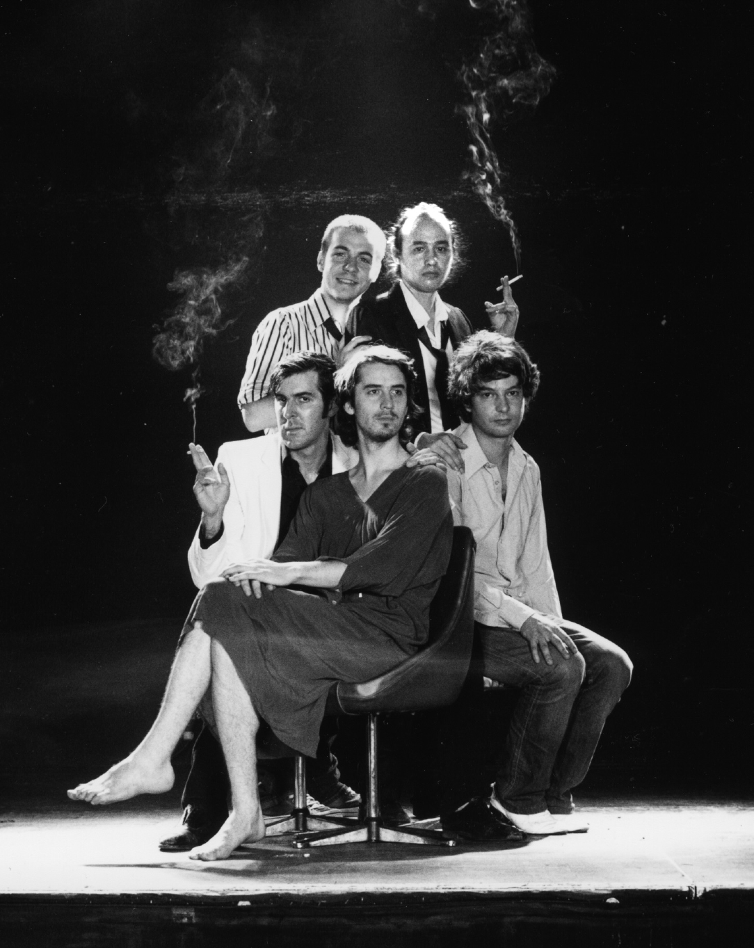 Les cinq membres du groupe Poni Hoax sur scène dans une atmosphère en noir et blanc.