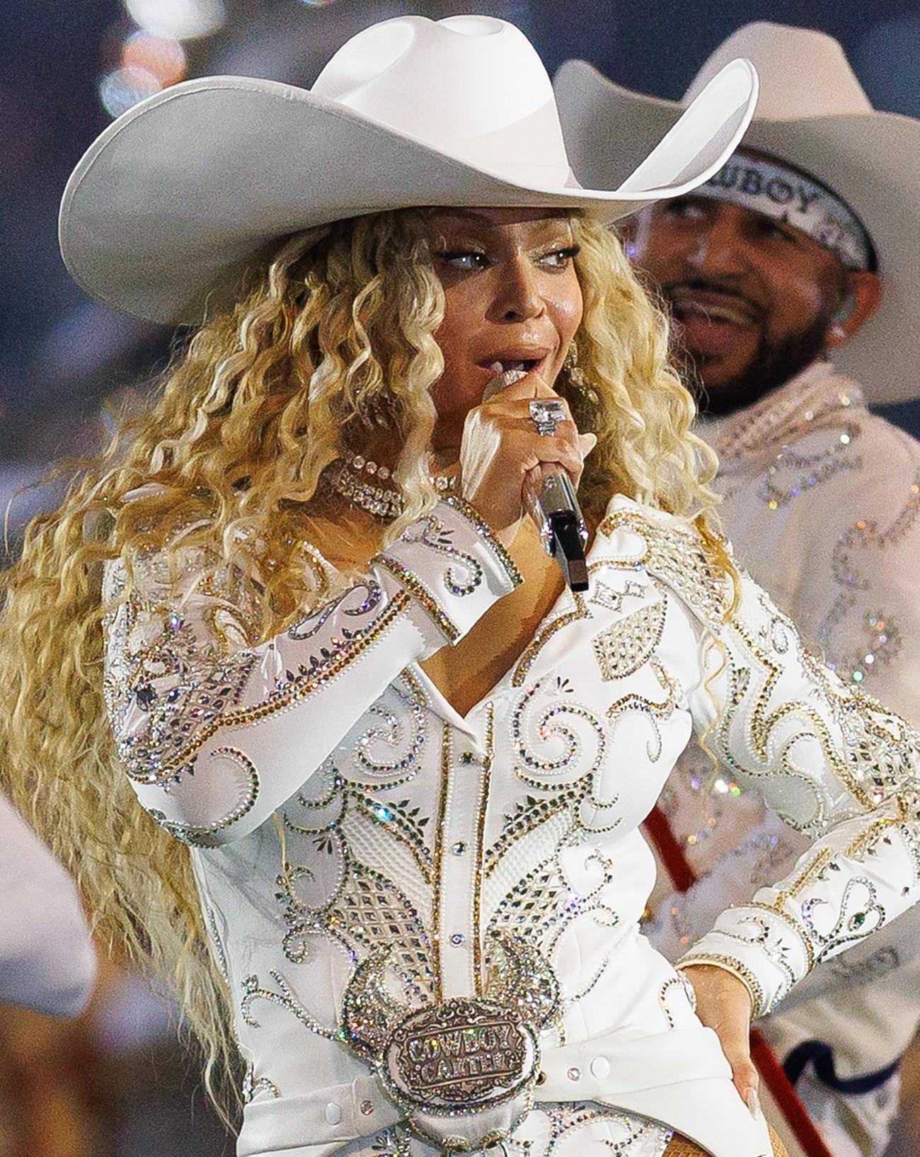 Attendue en concert à Paris en 2025, la chanteuse Beyoncé prend la pose sur scène dans une tenue de cowboy blanche.