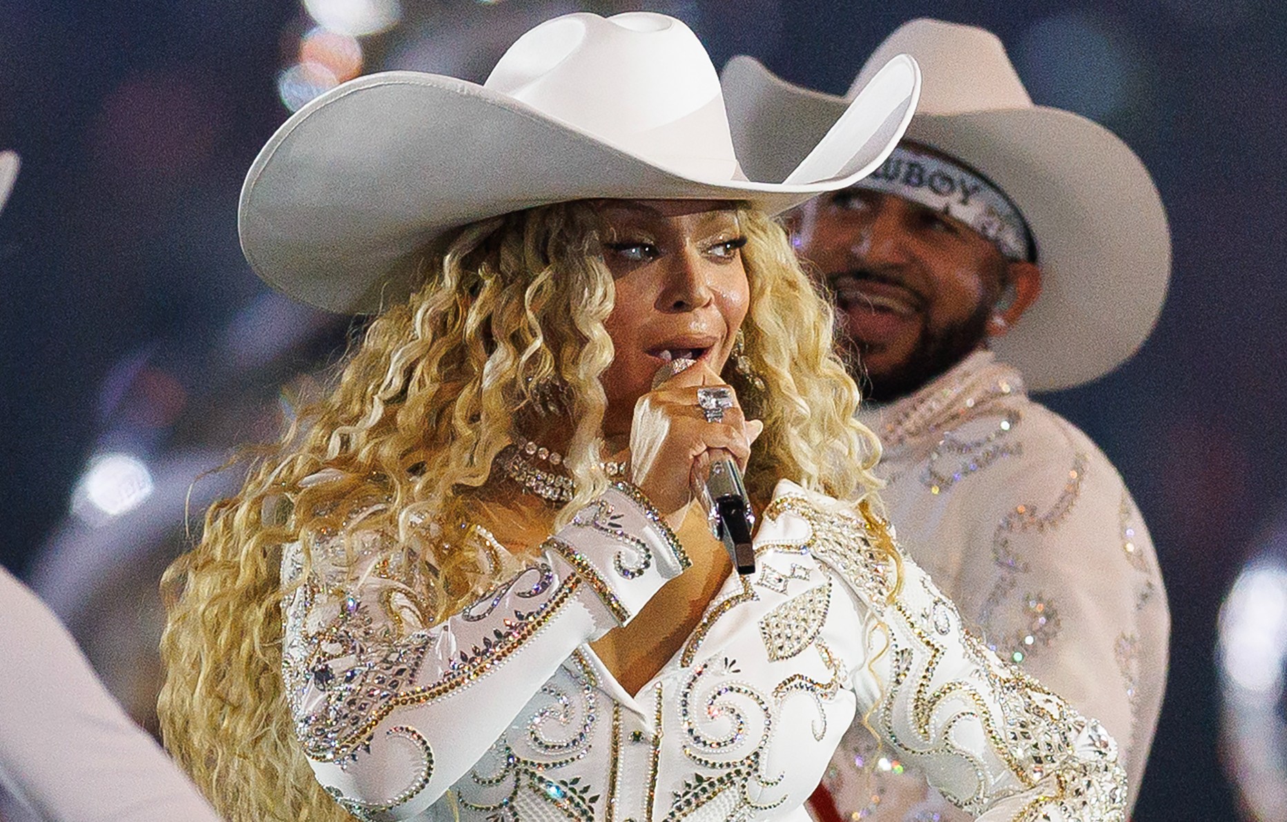 Attendue en concert à Paris en 2025, la chanteuse Beyoncé prend la pose sur scène dans une tenue de cowboy blanche.