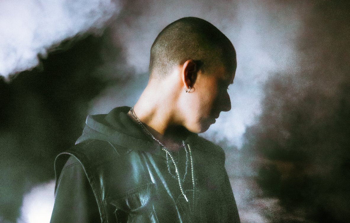 L'artiste Nziria pose le visage caché de la caméra, dans un nuage de fumée.