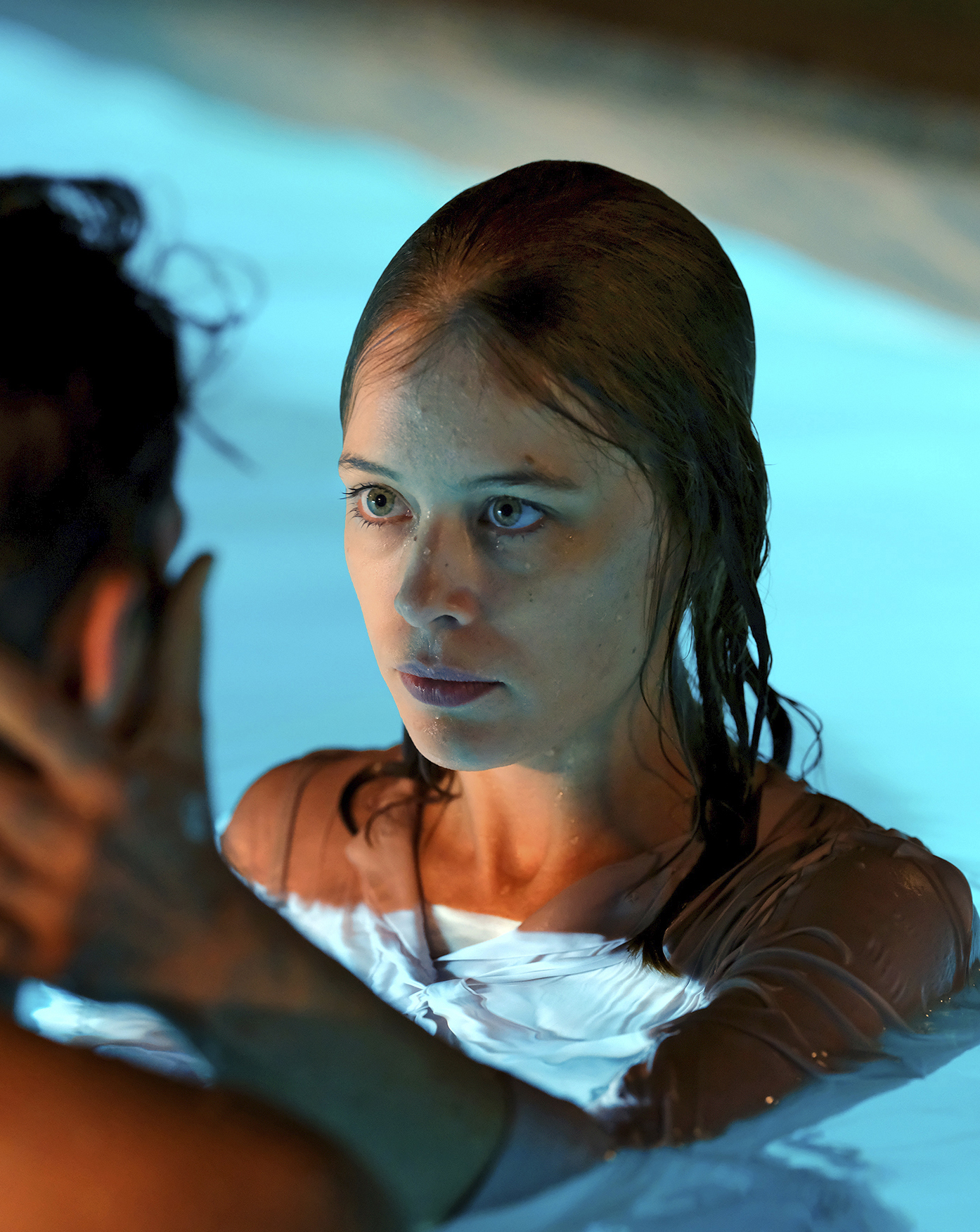 Paula Beer tient la tête d'un homme entre les mains dans une piscine dans le film Ondine (2020).
